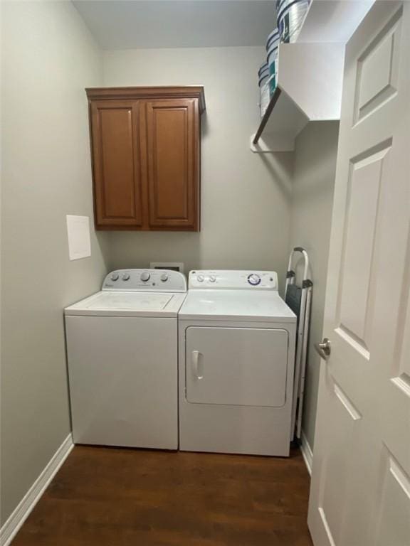 laundry area with dark hardwood / wood-style flooring, cabinets, and washing machine and dryer