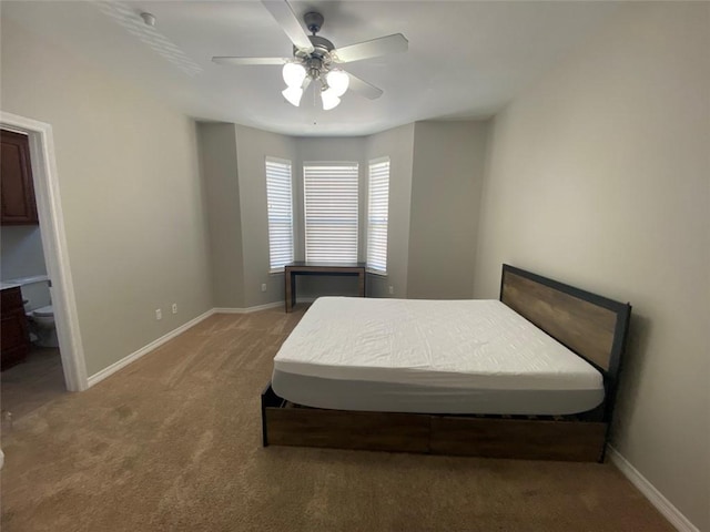 bedroom with ceiling fan, connected bathroom, and carpet flooring