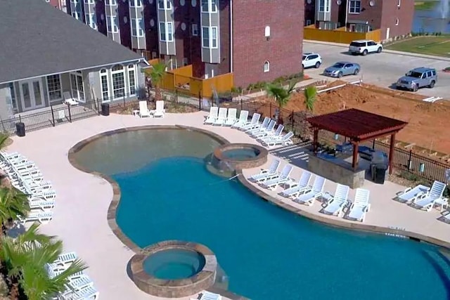 view of swimming pool featuring a patio area and a hot tub