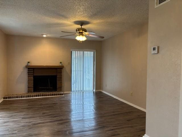 unfurnished living room featuring dark wood-type flooring, a fireplace, a textured ceiling, and ceiling fan