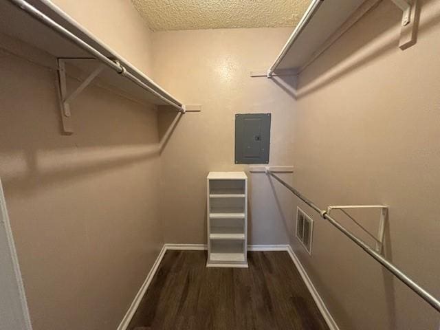 walk in closet with dark wood-type flooring and electric panel