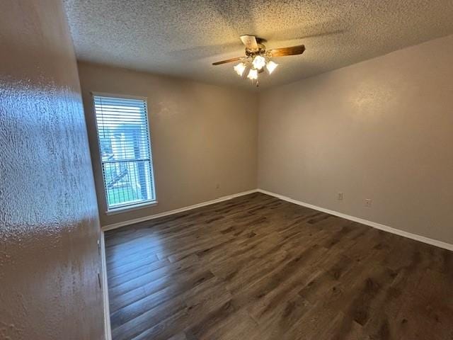 spare room featuring a textured ceiling, dark wood-type flooring, and ceiling fan