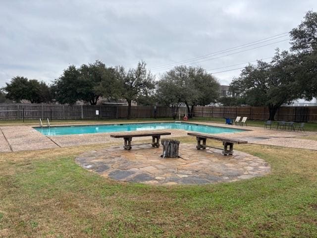 view of pool with a lawn and a patio