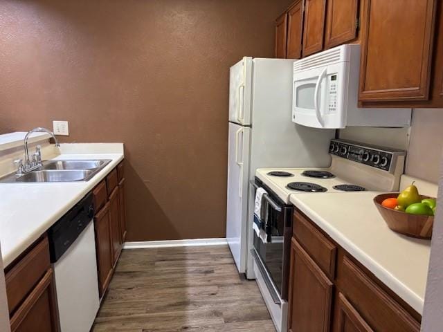 kitchen featuring sink, white appliances, and light hardwood / wood-style flooring