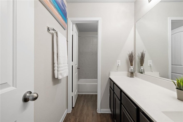 5745 Cerrillos Dr, Bryan, TX 77807 - full bathroom with vanity, wood finished floors, baseboards, and tub / shower combination