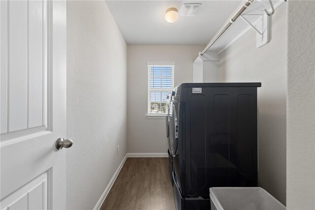 5745 Cerrillos Dr, Bryan, TX 77807 - washroom featuring wood finished floors, baseboards, and washer / clothes dryer