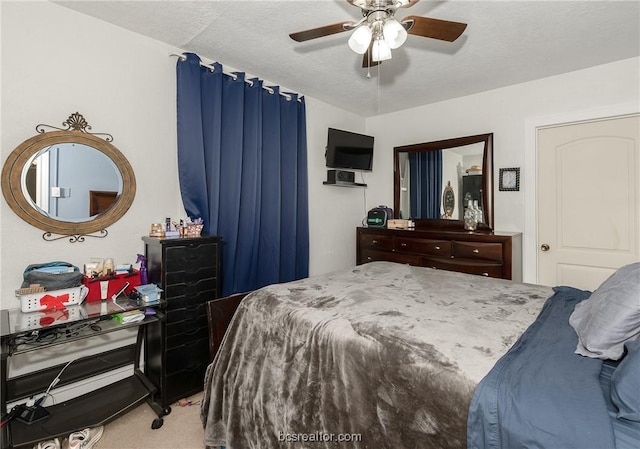 carpeted bedroom featuring ceiling fan and a textured ceiling