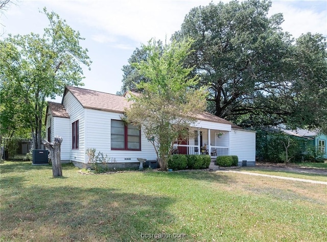 view of front of home featuring a front lawn, covered porch, and central AC