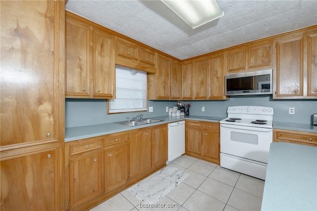 kitchen featuring a textured ceiling, sink, light tile patterned floors, and white appliances