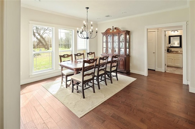 dining room featuring ornamental molding, dark hardwood / wood-style flooring, and a chandelier