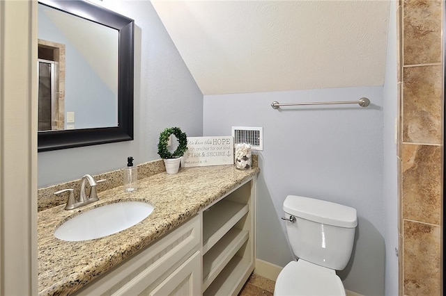 bathroom featuring lofted ceiling, toilet, and vanity