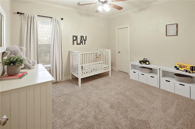 carpeted bedroom featuring ornamental molding, a nursery area, and ceiling fan