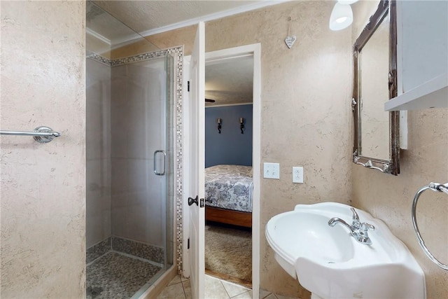 full bathroom with tile patterned flooring, a textured wall, ensuite bathroom, a shower stall, and a sink