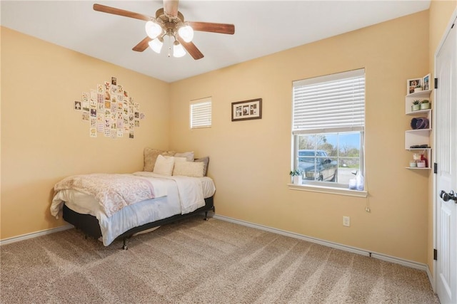 carpeted bedroom featuring baseboards and a ceiling fan