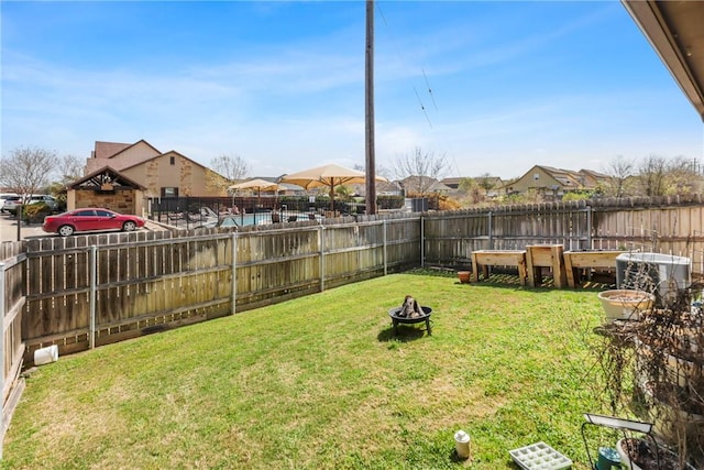 view of yard with a fenced backyard and a fire pit