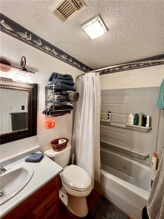 full bathroom featuring a textured ceiling, vanity, shower / tub combo, and toilet