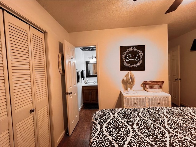 bedroom with ceiling fan, dark hardwood / wood-style flooring, ensuite bathroom, a textured ceiling, and a closet