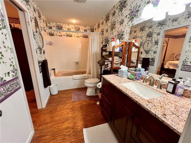 full bathroom with shower / bath combo, vanity, toilet, a textured ceiling, and wood-type flooring