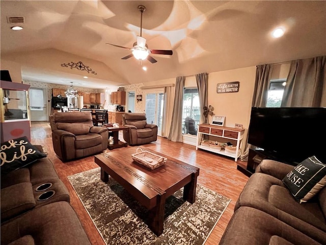 living room with ceiling fan, light hardwood / wood-style floors, and lofted ceiling