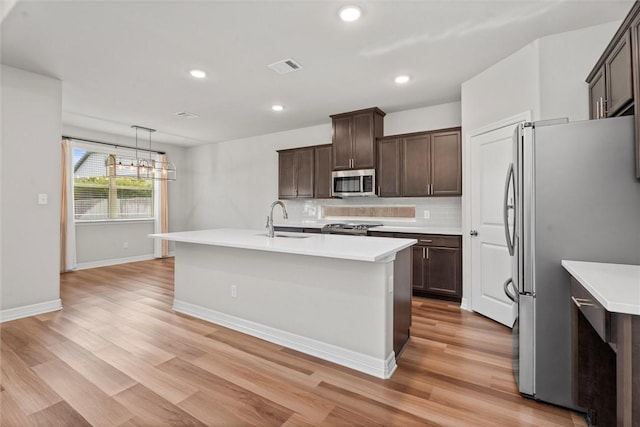 3008 Alpha Ct, Bryan, TX 77808 - kitchen with stainless steel appliances, a sink, light countertops, light wood-type flooring, and recessed lighting