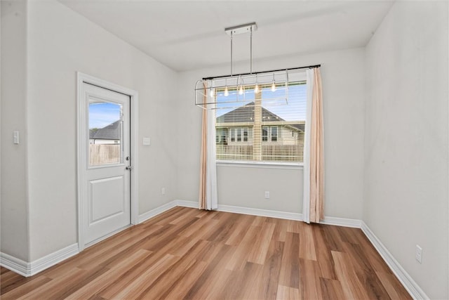 3008 Alpha Ct, Bryan, TX 77808 - unfurnished dining area with light wood-style floors, healthy amount of natural light, and baseboards
