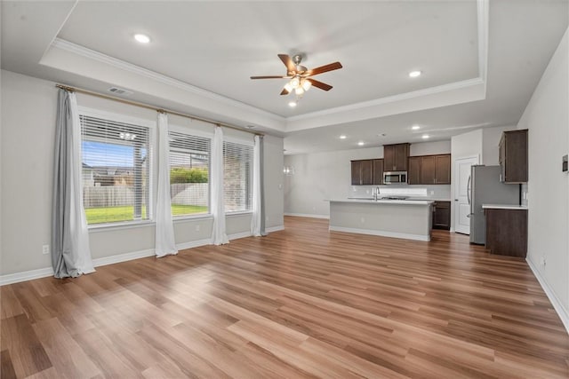 3008 Alpha Ct, Bryan, TX 77808 - unfurnished living room with a raised ceiling, ceiling fan, ornamental molding, light wood-style flooring, and recessed lighting