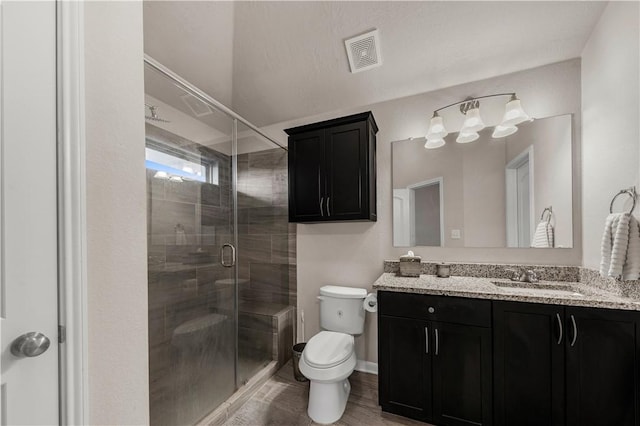 bathroom featuring hardwood / wood-style floors, vanity, toilet, and an enclosed shower