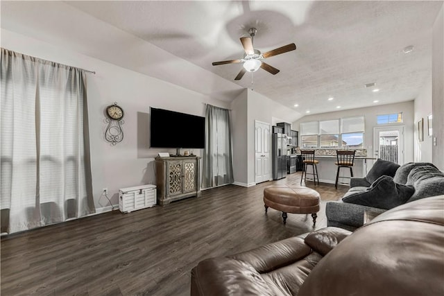 living room featuring a textured ceiling, ceiling fan, dark wood-type flooring, and vaulted ceiling