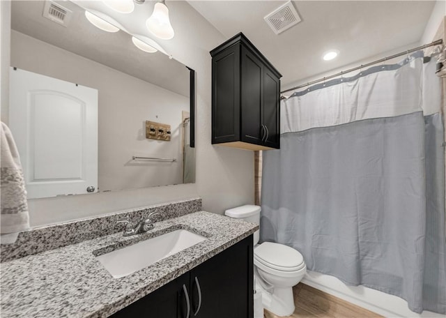 full bathroom featuring hardwood / wood-style floors, vanity, toilet, and shower / tub combo with curtain