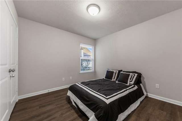 bedroom with dark wood-type flooring and a textured ceiling