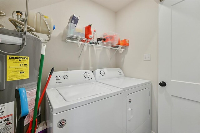washroom featuring washing machine and dryer, laundry area, and electric water heater