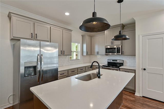 kitchen with a sink, gray cabinets, decorative backsplash, crown molding, and appliances with stainless steel finishes