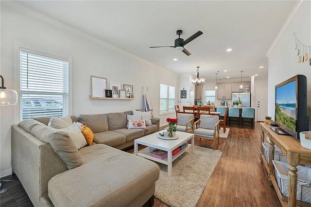 living area featuring recessed lighting, crown molding, dark wood-type flooring, and ceiling fan with notable chandelier