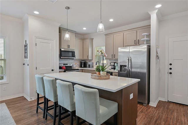 kitchen with a center island, light countertops, a kitchen bar, and appliances with stainless steel finishes