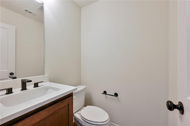 bathroom featuring visible vents, baseboards, vanity, and toilet