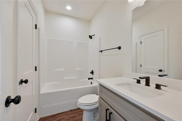 bathroom with wood finished floors, vanity, shower / washtub combination, toilet, and recessed lighting