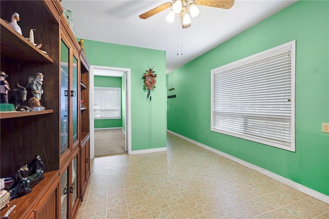 unfurnished room featuring ceiling fan and baseboards