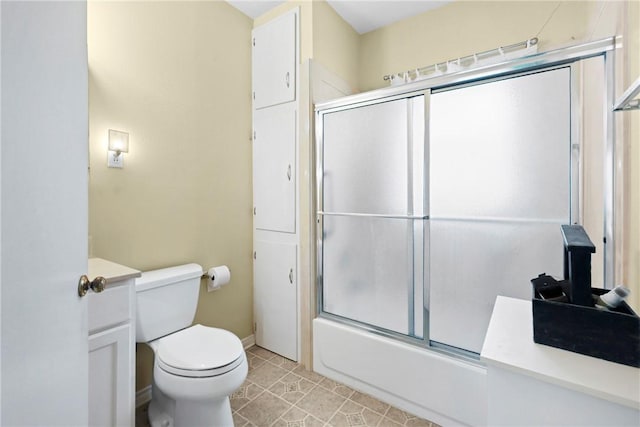 full bath featuring baseboards, bath / shower combo with glass door, toilet, tile patterned floors, and vanity