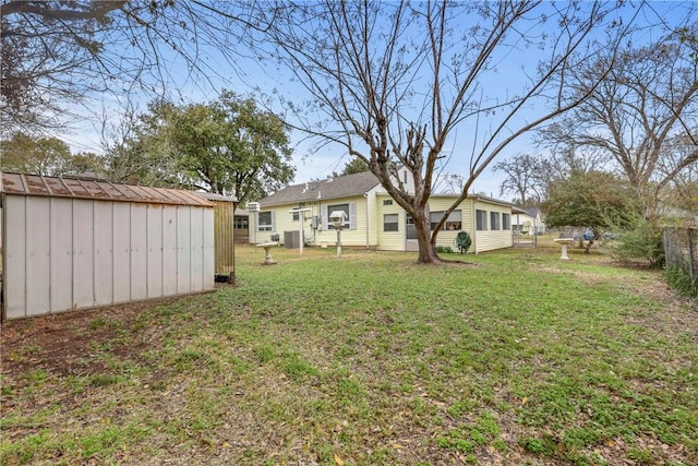 view of yard with an outbuilding, a storage unit, and fence