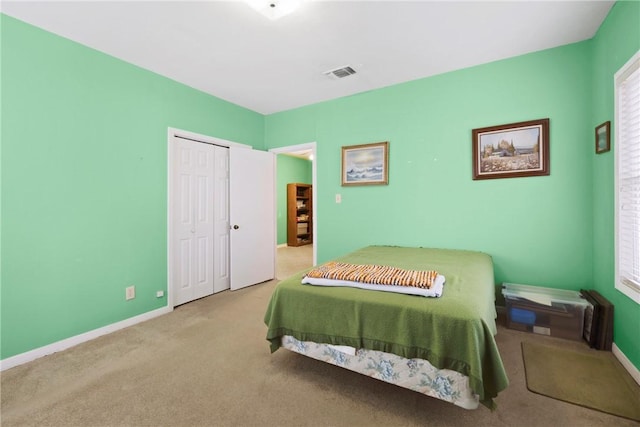 bedroom featuring carpet floors, a closet, visible vents, and baseboards