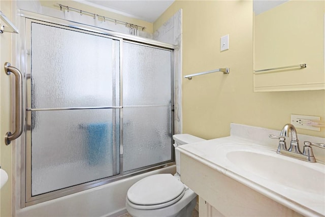 bathroom with toilet, shower / bath combination with glass door, and vanity