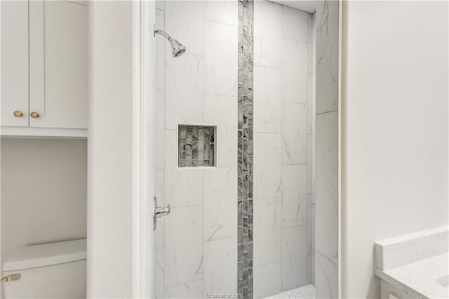 full bathroom with a marble finish shower and toilet