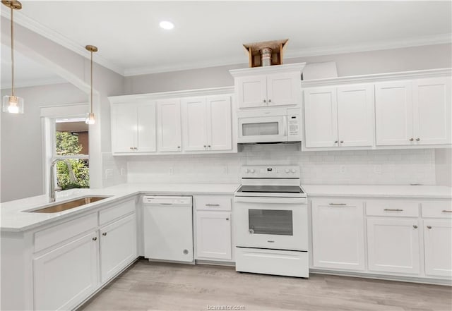 kitchen with white appliances, light wood-type flooring, light countertops, white cabinetry, and a sink