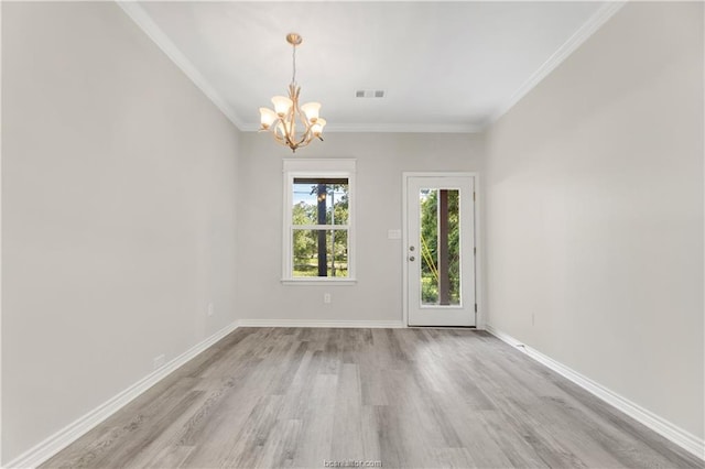 empty room with visible vents, wood finished floors, baseboards, an inviting chandelier, and ornamental molding
