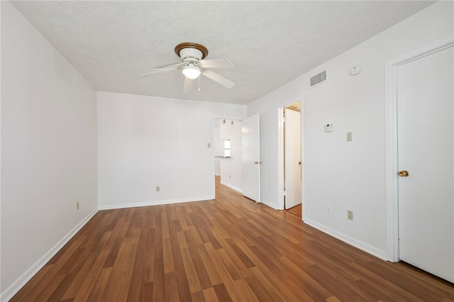 4441 Old College Rd, Bryan, TX 77801 - unfurnished room featuring ceiling fan, wood finished floors, a textured ceiling, and a smoke detector