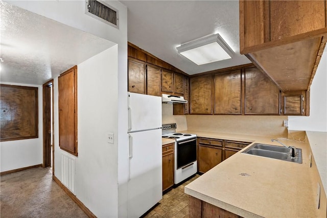 kitchen featuring sink, white appliances, and a textured ceiling