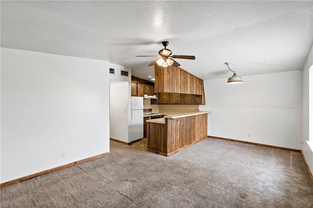 kitchen with light colored carpet, hanging light fixtures, white refrigerator, and kitchen peninsula