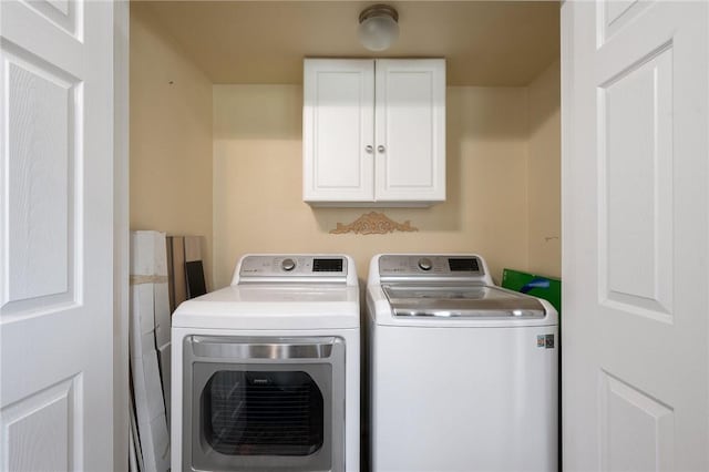 laundry room with cabinets and washing machine and dryer