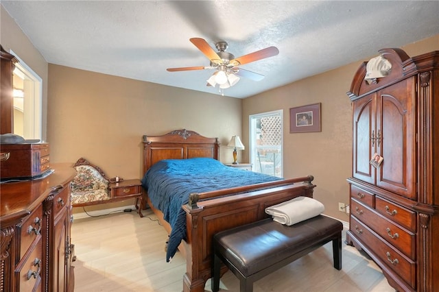 bedroom with a textured ceiling, light hardwood / wood-style flooring, and ceiling fan