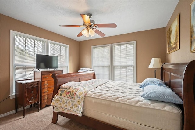 carpeted bedroom featuring ceiling fan and a textured ceiling